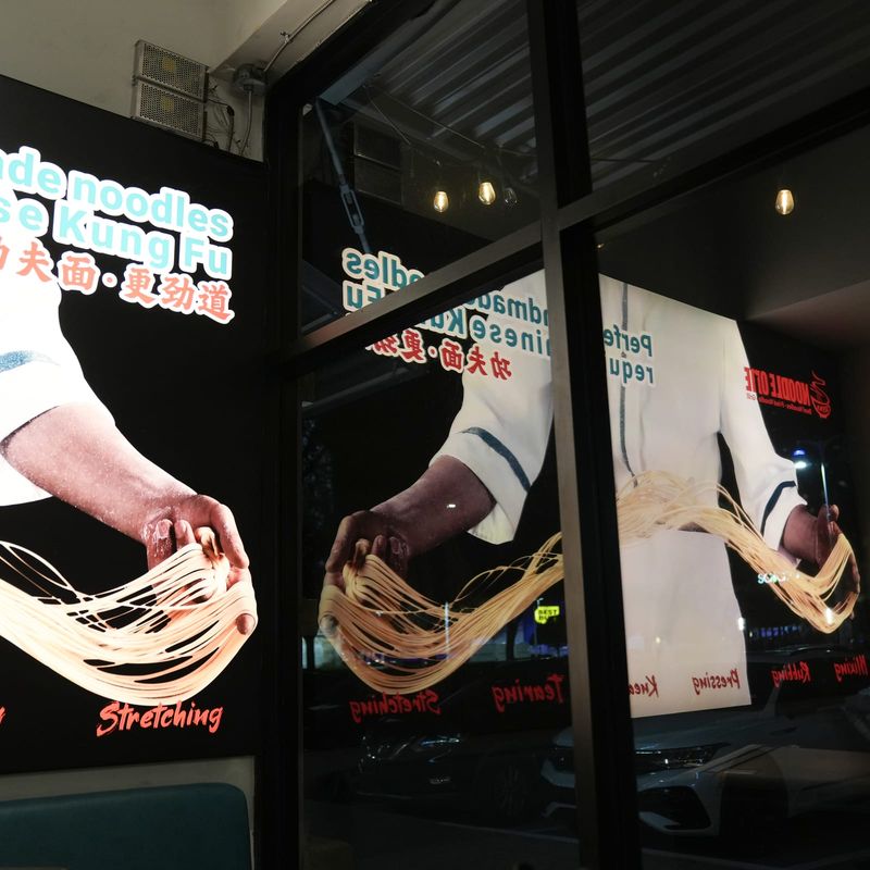 Storefront window with the hand-pulled noodle poster